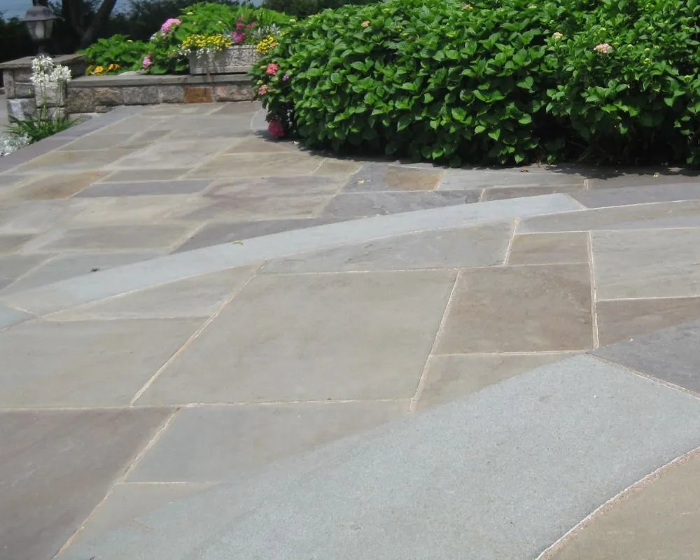 Random-cut bluestone patio with fieldstone walls and hydrangea border in Bedford NY